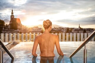 Woman in infinity pool at Paracelsusbad in Salzburg with Müllner church in background | © Paracelsusbad / Ch. Wöckinger