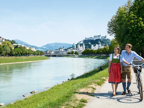 Couple with bike at the Salzach | © Tourismus Salzburg